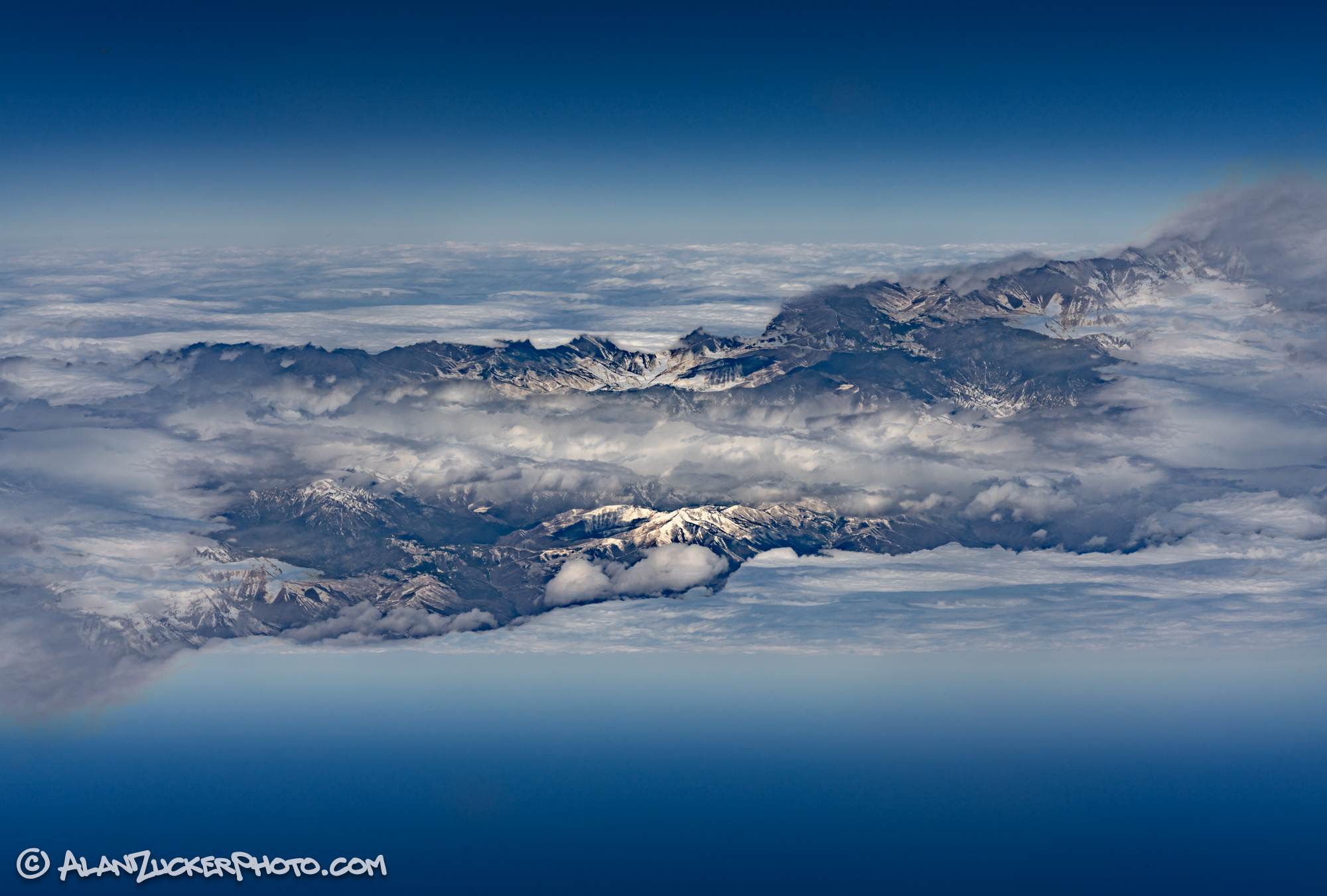 mirror image of land, clouds and sky